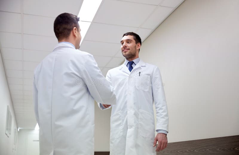 Smiling doctors at hospital doing handshake