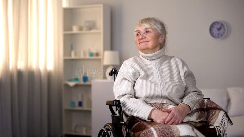 Smiling elderly female sitting wheelchair covered blanket, happy clinic patient stock image Smiling elderly female sitting wheelchair covered blanket, happy clinic patient stock image