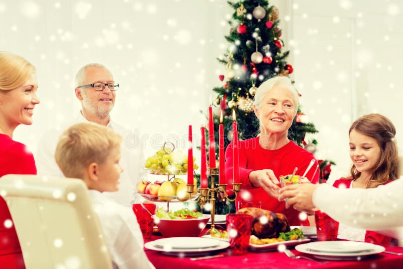 Smiling family having holiday dinner at home. Family, holidays, generation, christmas and people concept - smiling family having dinner at home stock photo