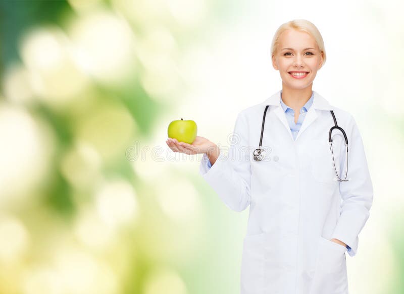 Smiling female doctor with green apple