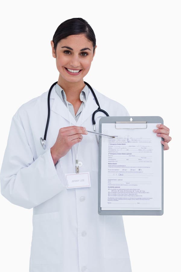 Smiling female doctor pointing at form against a white background
