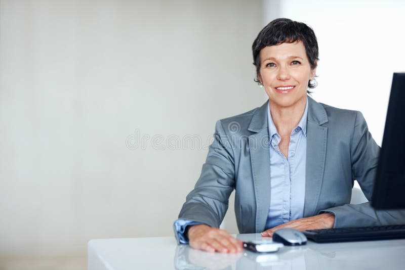 Smiling Female Executive at Office Desk. Portrait of Successful Female