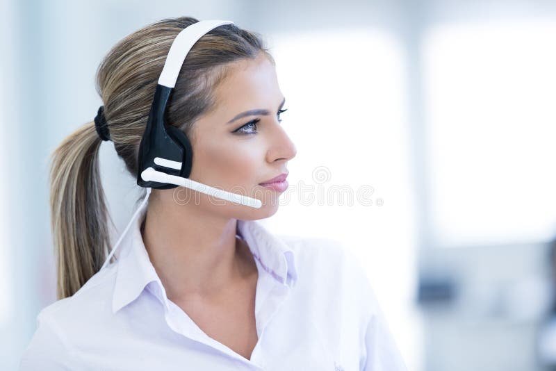 Smiling female helpline operator with headphones stock photo