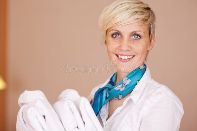 Smiling Female Housekeeper With Bathrobes