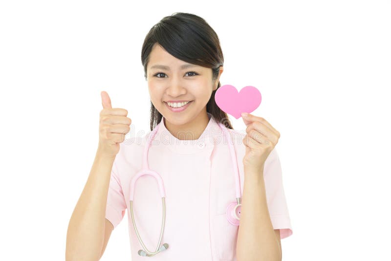 Portrait of a female nurse holding pink heart love symbol. Portrait of a female nurse holding pink heart love symbol