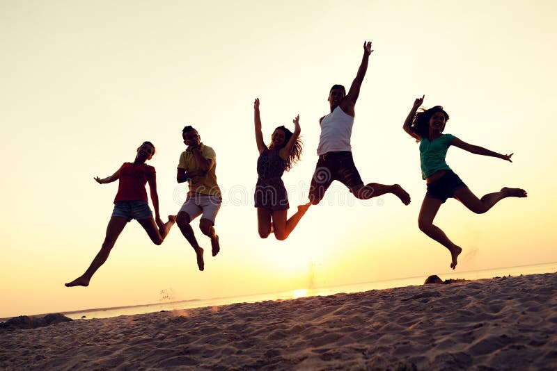 Smiling friends dancing and jumping on beach royalty free stock images Smiling friends dancing and jumping on beach royalty free stock images