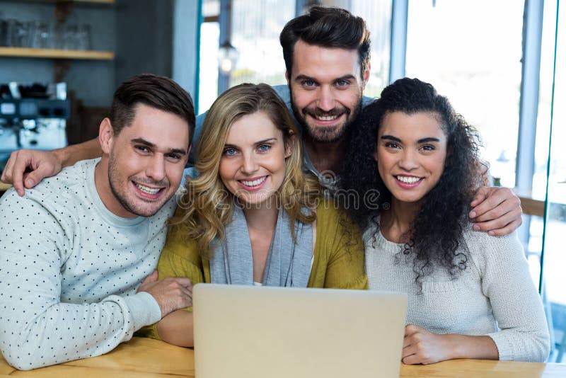 Smiling friends sitting with arm around in cafÃ© royalty free stock photos