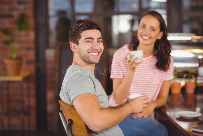 Smiling friends sitting and drinking coffee royalty free stock photo