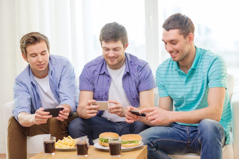 Smiling friends taking picture of food at home