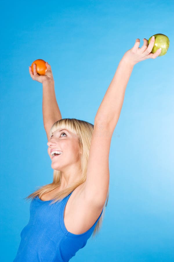 Smiling girl with an apple and an orange