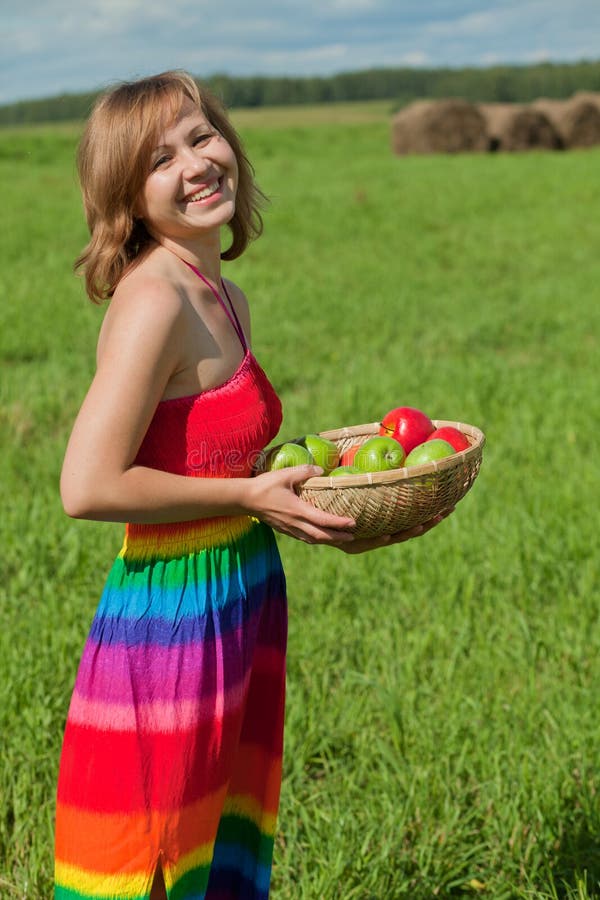 Smiling girl with a basket of apples royalty free stock photo
