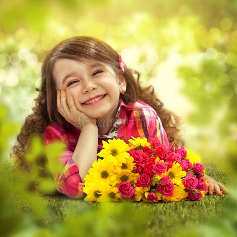 Smiling girl with big bouquet of flowers lying on grass. Spring, Mothers day, family holiday, Happiness concept.