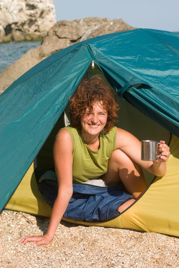 Smiling girl with cap of coffee ta sea coast