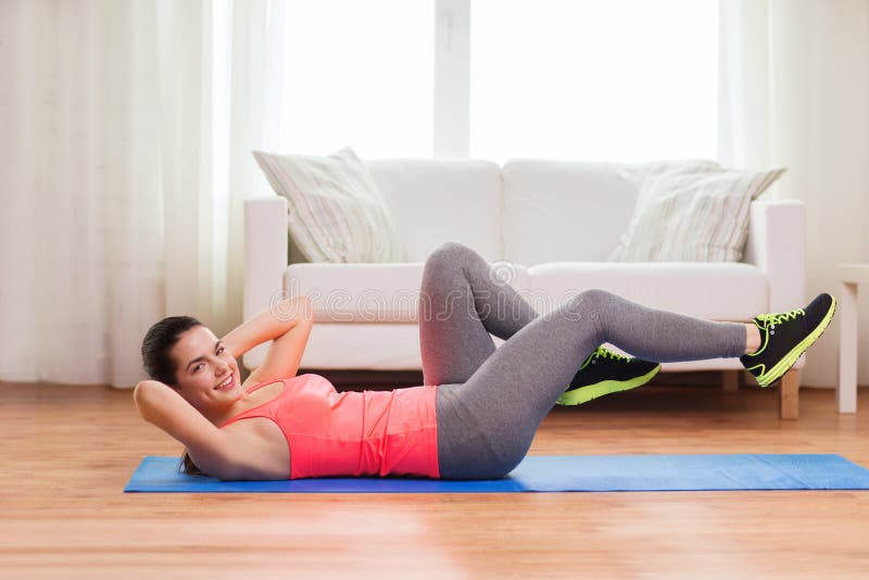 Smiling girl doing exercise on floor at home royalty free stock images