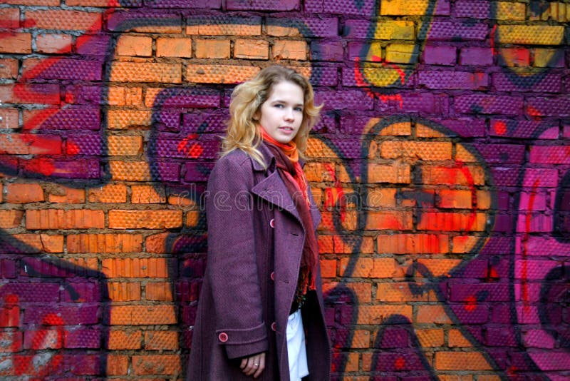 Smiling girl in front of a graffiti wall