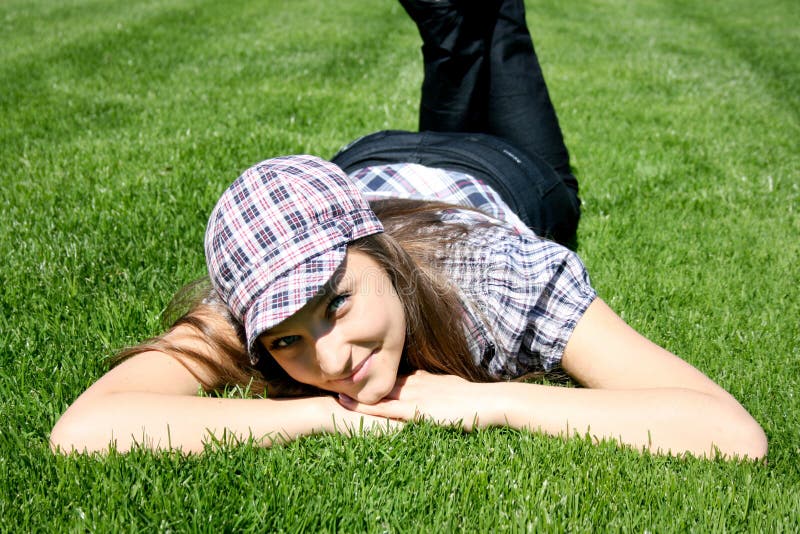 Smiling girl lays on the grass