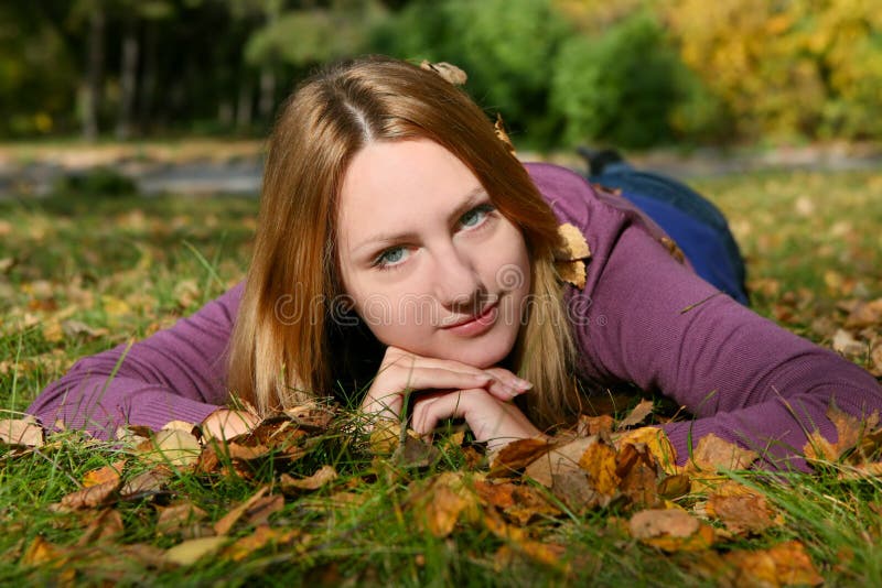 The smiling girl lays on a grass