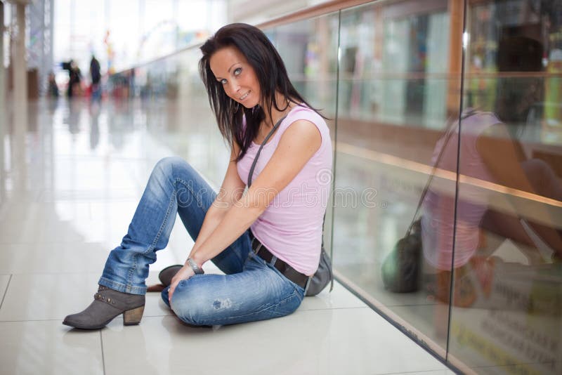 Smiling girl is sitting in the shopping mall