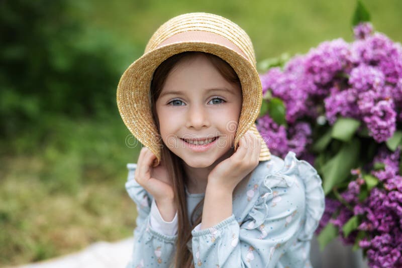 Smiling Girl in Straw Hat with Lilac Flowers, Looking at the Camera ...