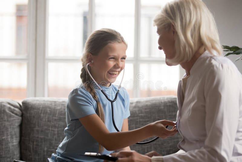 Smiling girl wear stethoscope play with doctor at home