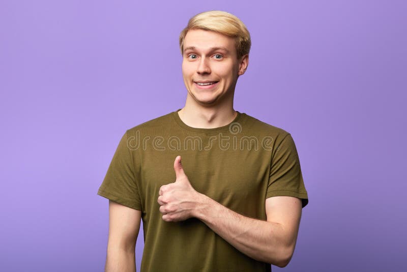 Smiling gorgeous man with thumb up posing to the camera royalty free stock photography Smiling gorgeous man with thumb up posing to the camera royalty free stock photography