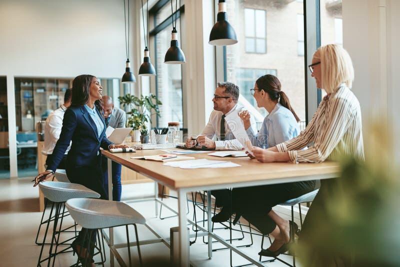 Smiling group of diverse businesspeople talking together around stock images Smiling group of diverse businesspeople talking together around stock images