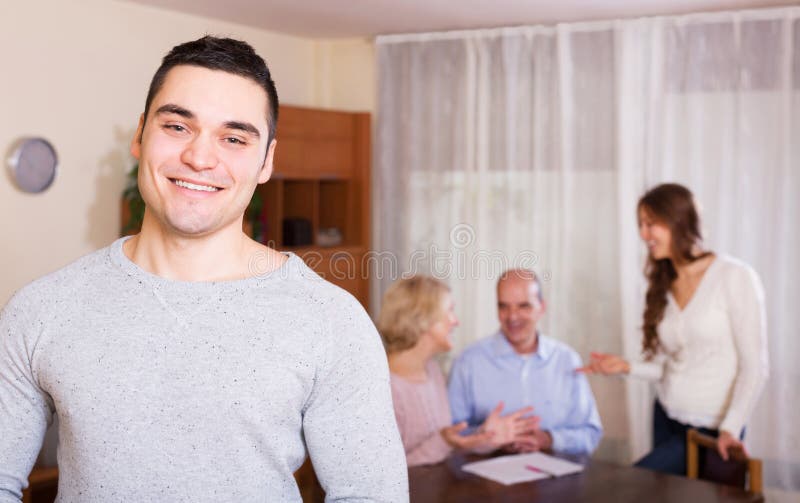 Smiling guy and big family with agent at distance indoor royalty free stock photos Smiling guy and big family with agent at distance indoor royalty free stock photos