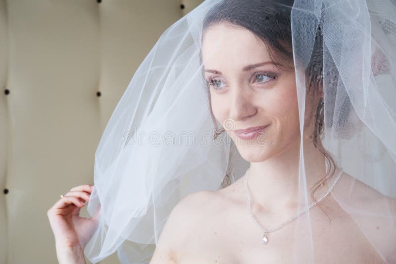 Smiling happy bride with white veil