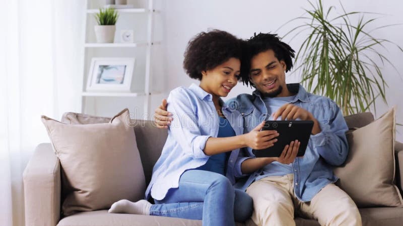 Smiling happy couple with tablet pc at home