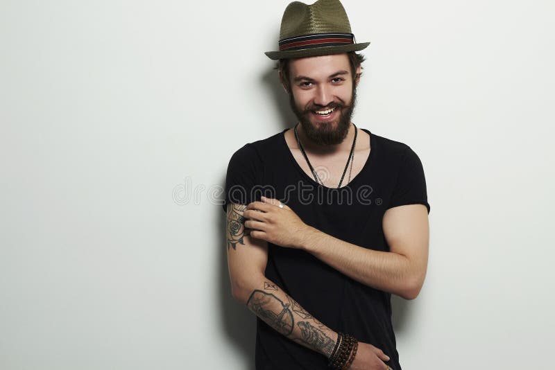 Smiling Hipster boy. handsome man in hat. Brutal bearded boy with tattoo