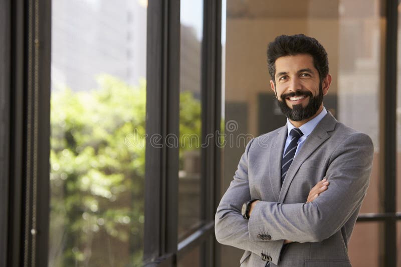 Smiling Hispanic businessman with arms crossed, to camera stock photography Smiling Hispanic businessman with arms crossed, to camera stock photography