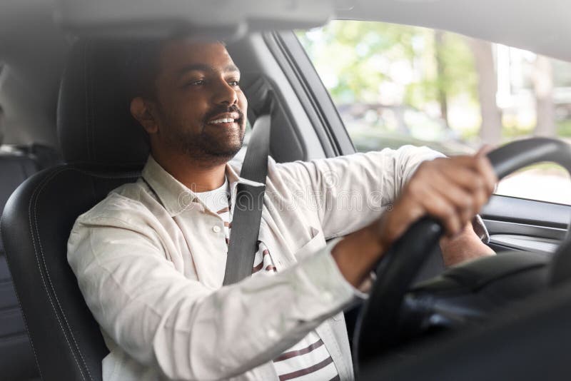 smiling indian man or driver driving car