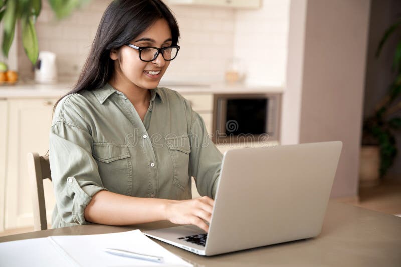 Smiling Indian Young Woman Typing On Laptop Computer Working At Home
