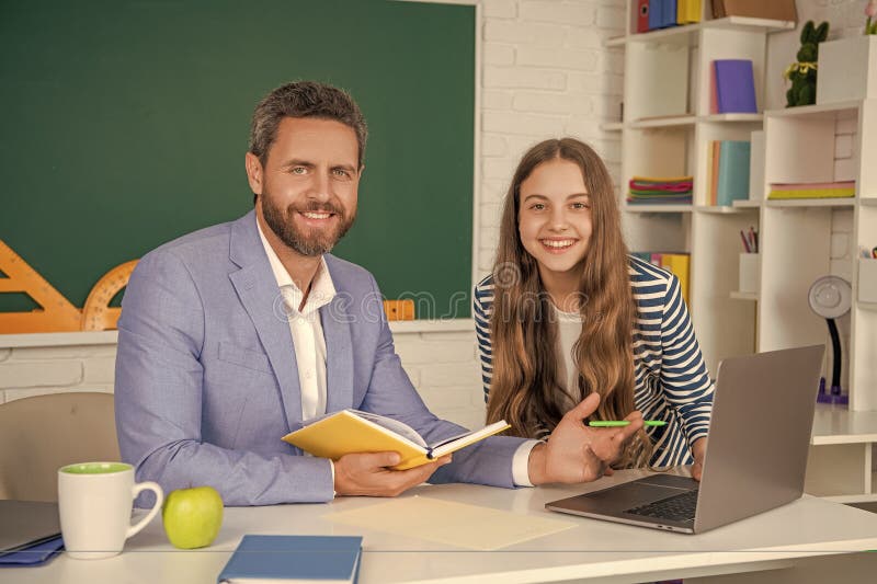 Smiling kid with man teacher in classroom. education stock photography