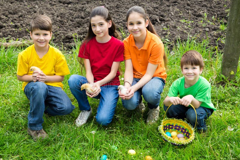 Smiling kids at green grass holding a little chickens, easter co royalty free stock photos Smiling kids at green grass holding a little chickens, easter co royalty free stock photos