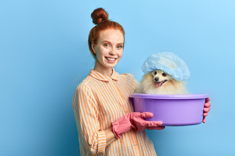 Smiling kind girl loves her pet, gets pleasure from washing it