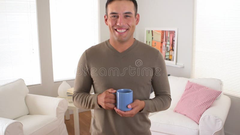 Smiling Latino man with cup of coffee stock video footage