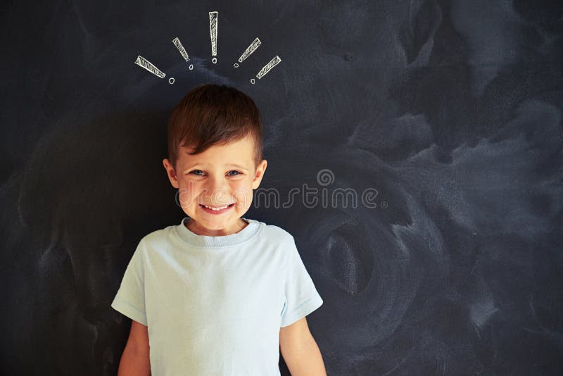 Smiling Little Boy Against Chalk Drawing of Exclamation Marks Stock