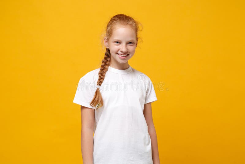 Two young little girls 12-13 years old in white t-shirt blue school uniform  dresses isolated on yellow background children studio portrait Childhood  kids education lifestyle concept Mock up copy space Stock Photo