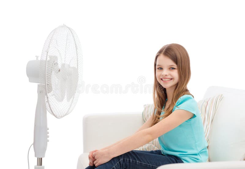 Smiling little girl with big fan at home