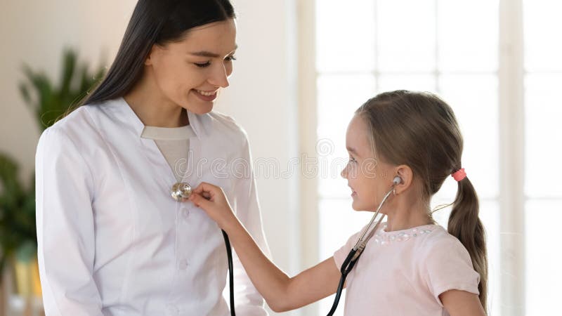 Smiling little girl play with female nurse in hospital