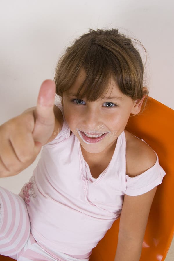 Smiling little girl showing thumb s up