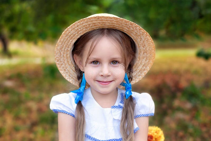 Smiling Little Girl with Two Pigtails on Her Head and in a Straw Hat in ...