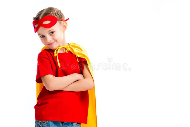 Smiling little supergirl wearing yellow cape with red mask for eyes on forehead