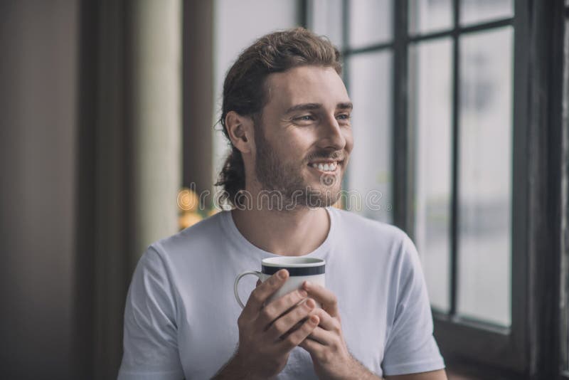 Smiling Long-haired Man Holding a Cup of Drink. Stock Image - Image of ...