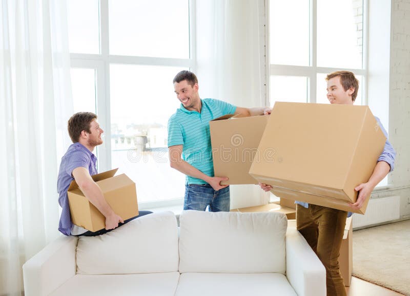 Smiling male friends carrying boxes at new place stock photos Smiling male friends carrying boxes at new place stock photos