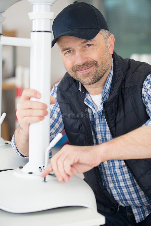 Smiling man assembling office stool stock image