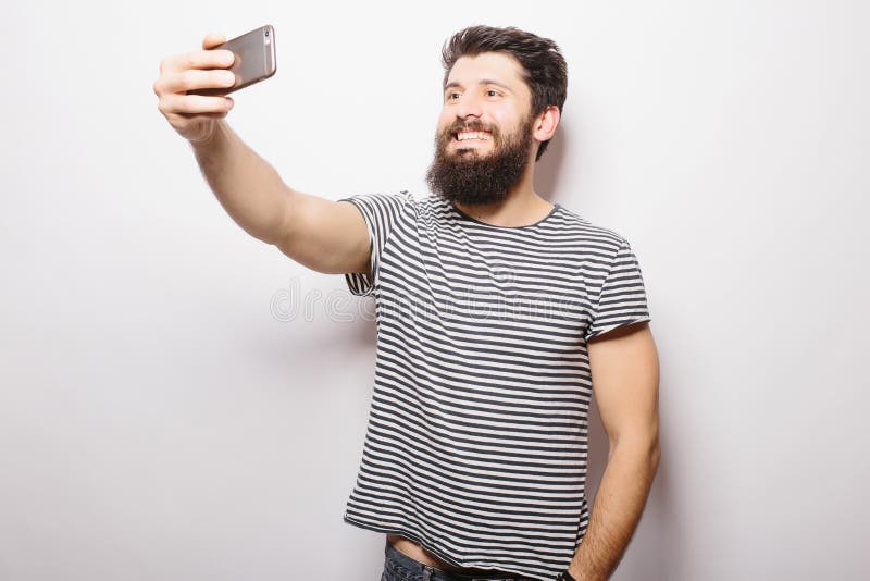 Smiling Man With Beard Standing On White Background And Taking Selfie ...