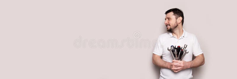 Smiling man with bouquet of wrenches and screwdrivers banner royalty free stock photo