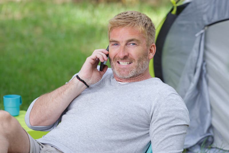 Smiling Man with Cellphone while Camping Stock Photo - Image of male ...